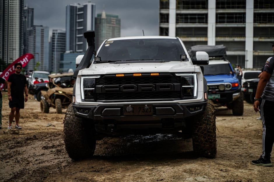Dynamic off-road vehicles displayed against Pasig's skyscrapers in a lively outdoor event. (Photo by Harvey Tan Villarino on Pexels)