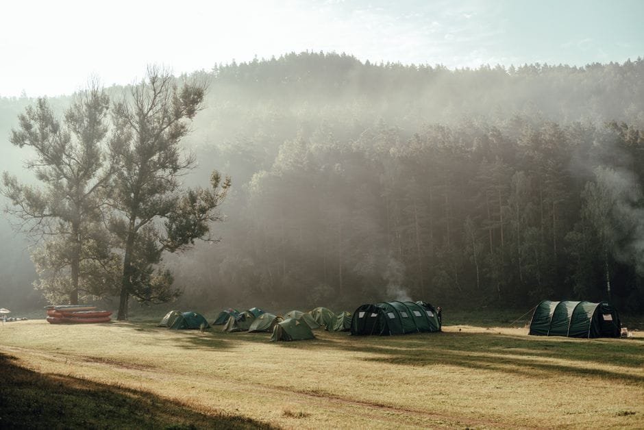 A serene campsite with tents in a misty forest clearing in Russia. (Photo by Евгения Егорова on Pexels)