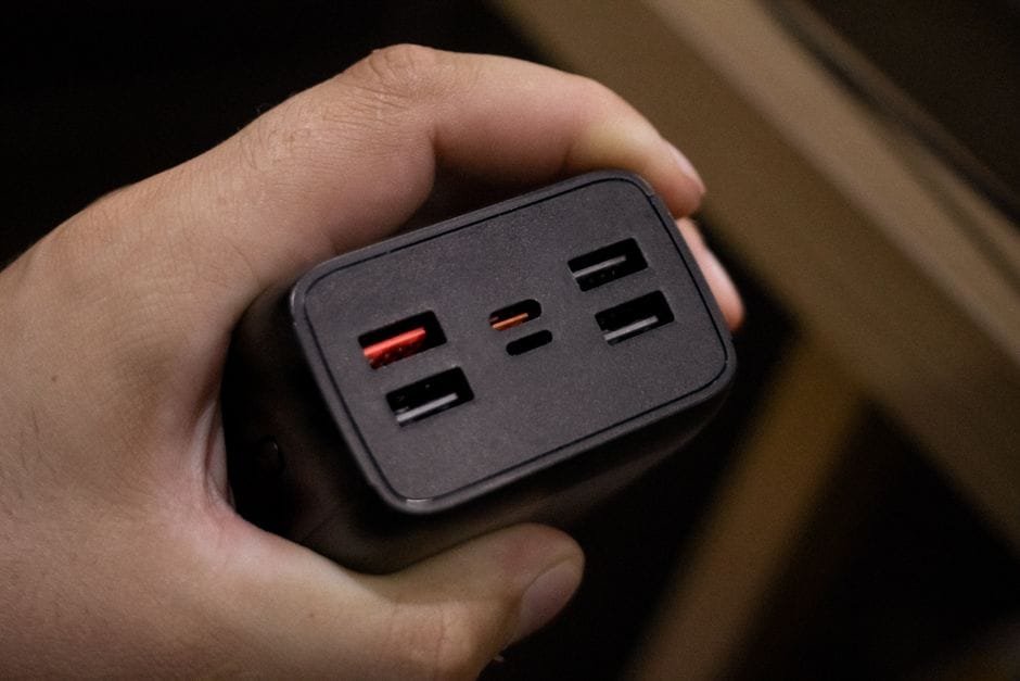 Close-up shot of a hand holding a multi-USB port power adapter, highlighting its ports. (Photo by Pedro Paiva on Pexels)