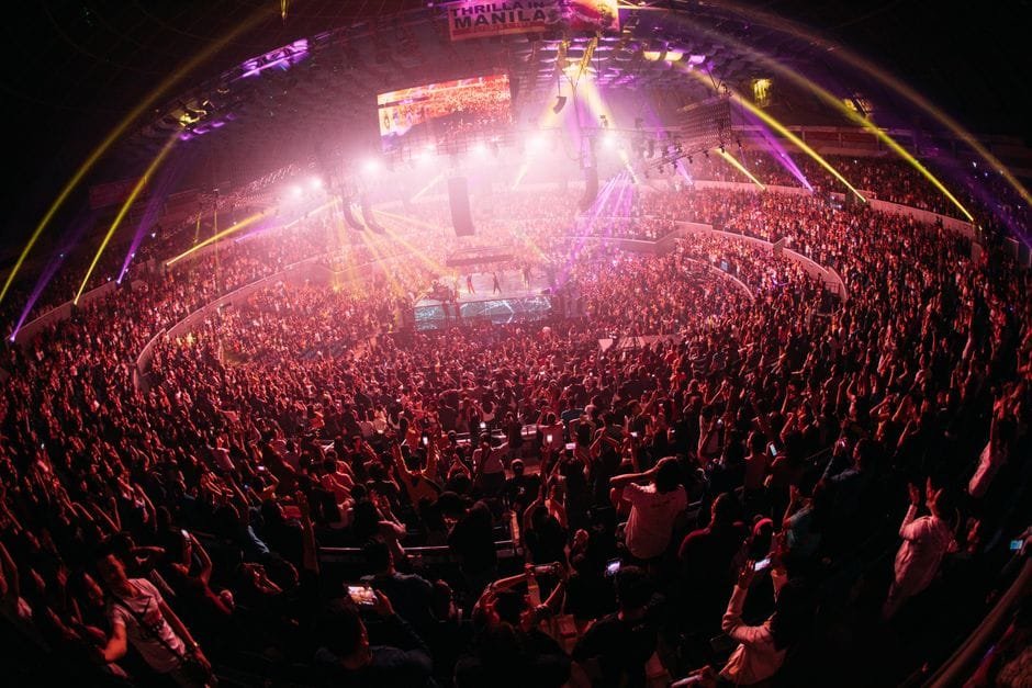 Vibrant crowd enjoying a live concert in a bustling Manila arena at night. (Photo by Thomas Lineweaver on Pexels)