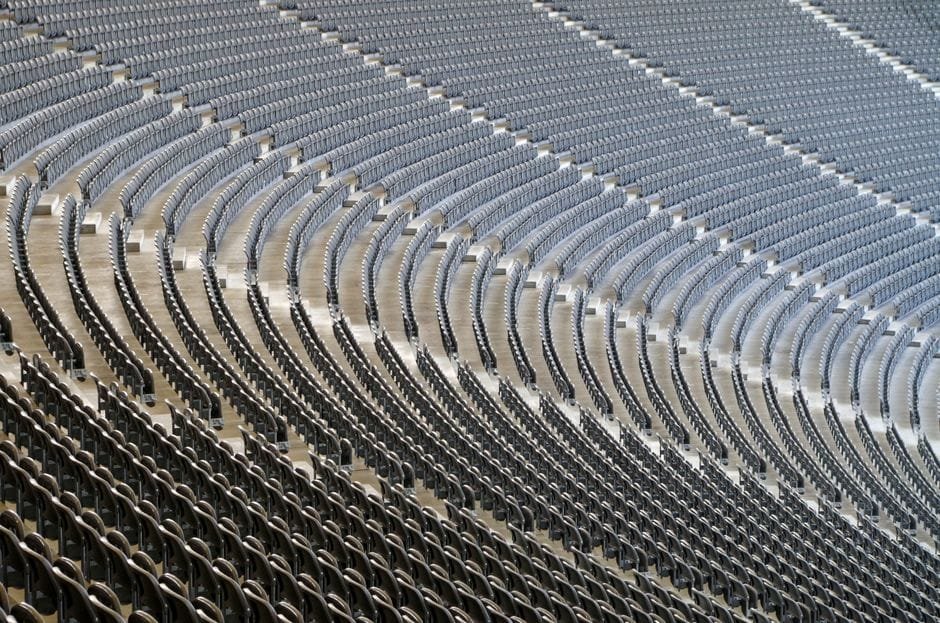 An empty stadium with cascading rows of seats, perfect for events and sports. (Photo by wal_ 172619 on Pexels)