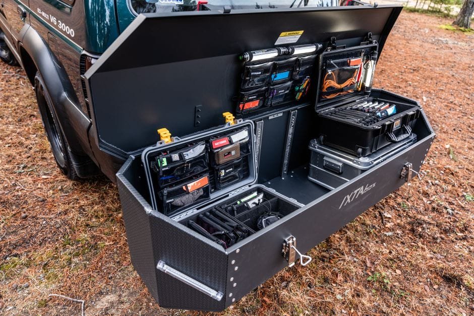 Open vehicle trunk showcasing organized tool storage with compartments and gadgets, parked outdoors. (Photo by Andreas Näslund on Pexels)