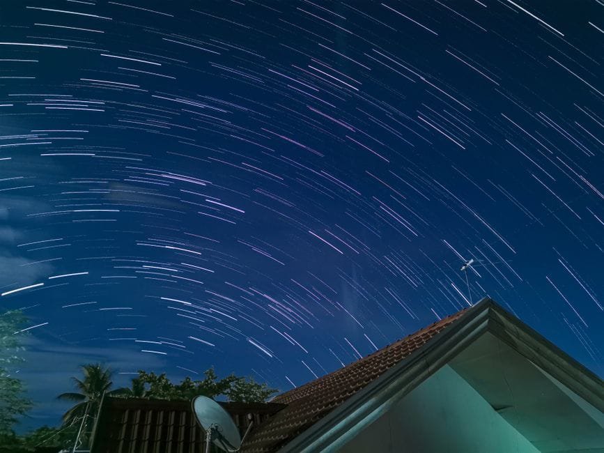 Stunning star trails photograph over a roof in Tagum City, displaying a vibrant night sky. (Photo by Kristel Escurzon on Pexels)