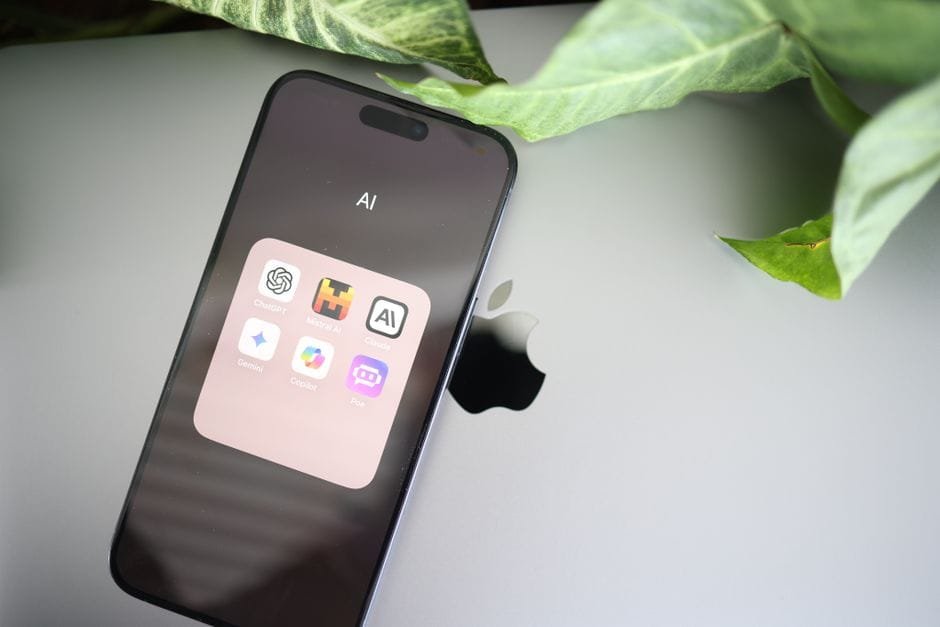 A smartphone showcasing AI apps on a laptop, surrounded by greenery, symbolizing tech and nature integration. (Photo by Solen Feyissa on Pexels)