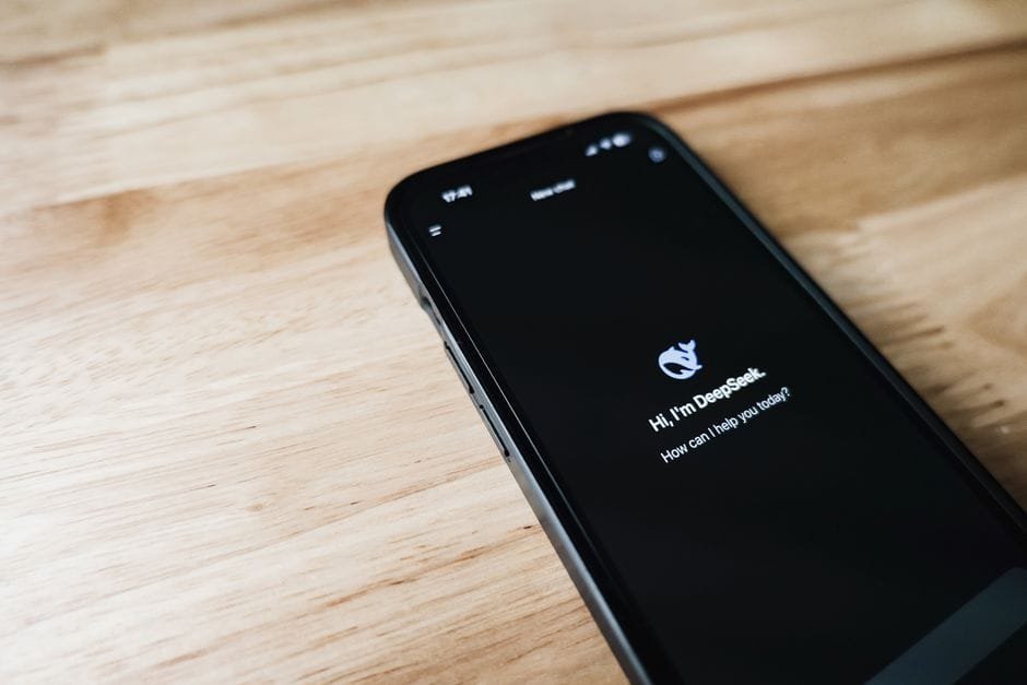 Close-up of a smartphone with DeepSeek virtual assistant on screen, placed on a wooden surface. (Photo by Airam Dato-on on Pexels)