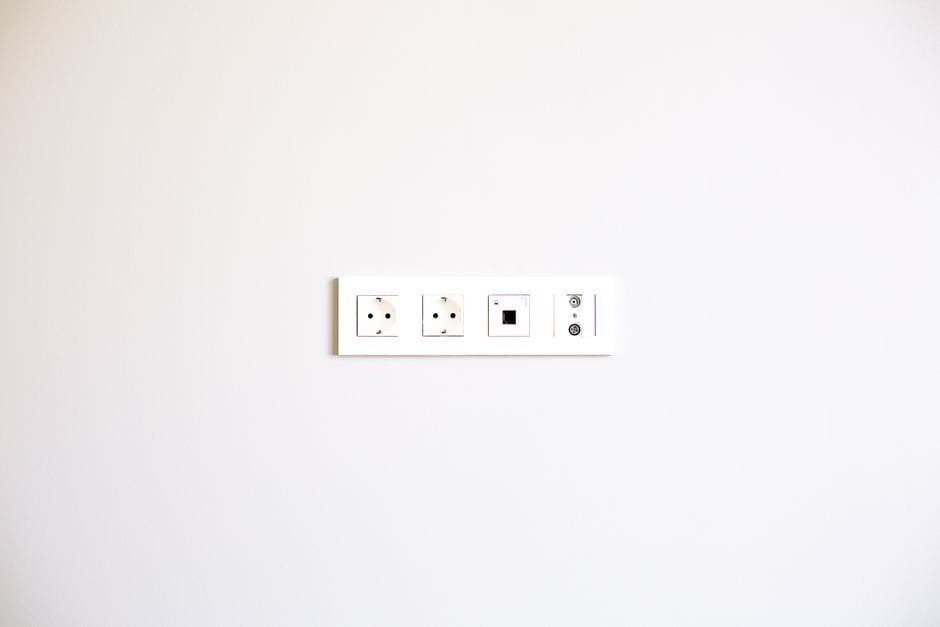 A minimalist image showcasing a modern wall outlet array on a bright white wall. (Photo by La Miko on Pexels)