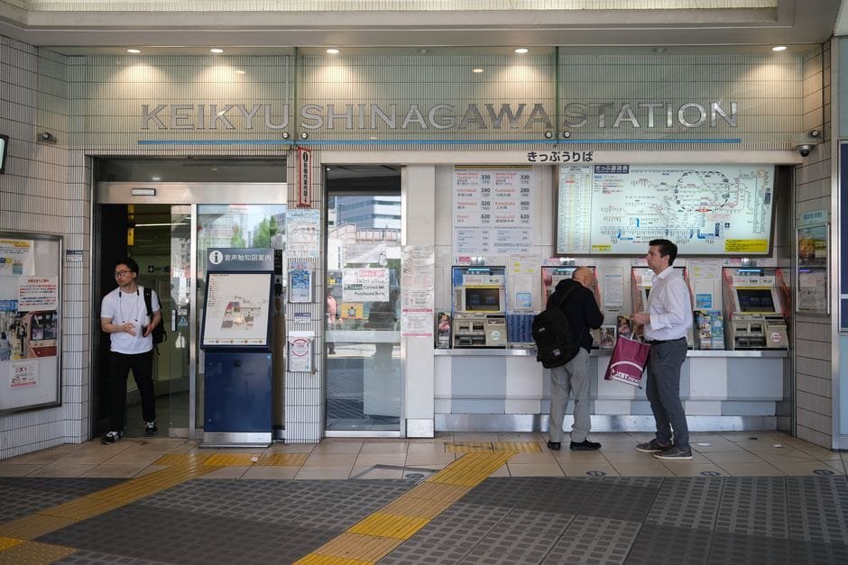 People at ticket machines at Keikyu Shinagawa Station, Tokyo, Japan, bustling rail station scene. (Photo by Huu Huynh on Pexels)