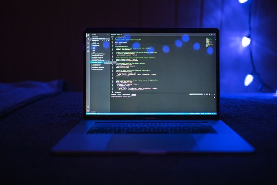 Close-up of a laptop screen displaying code, set against a dark backdrop with blue lighting for a tech-focused ambiance. (Photo by Nemuel Sereti on Pexels)