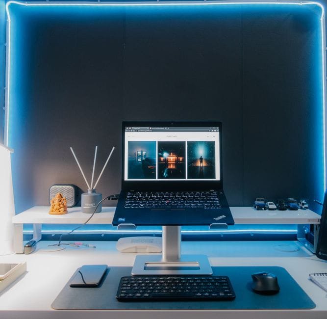 Contemporary desk setup featuring a laptop, electronic accessories, and neon lighting for a stylish workspace. (Photo by Pramod  Tiwari on Pexels)