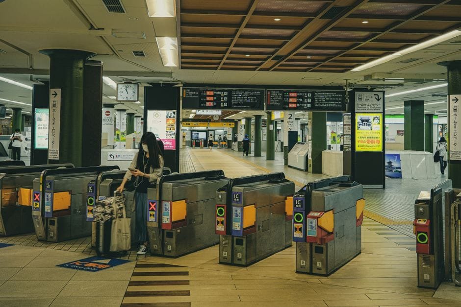 A Japanese railway station in Nara featuring ticket gates and travelers, illustrating urban transit life. (Photo by Huu Huynh on Pexels)