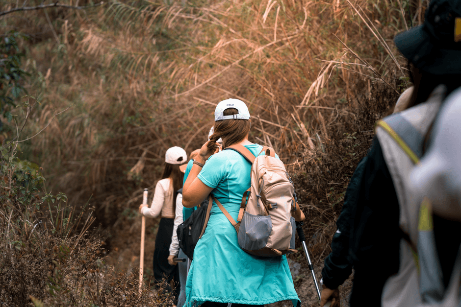 Group of women hiking through lush vegetation in Botolan, Philippines. (Photo by Ramius Aquiler on Pexels)