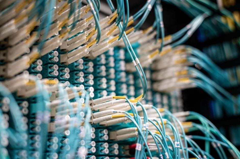 From below of fiber optic switch with sockets and connected rubber cables on blurred background (Photo by Brett Sayles on Pexels)