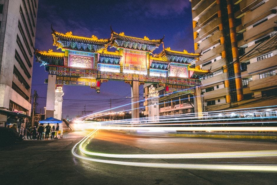 A vibrant night scene capturing the illuminated Chinese gate in Manila, showcasing cultural architecture and city life. (Photo by Jose Daniel Araneta Domingo on Pexels)