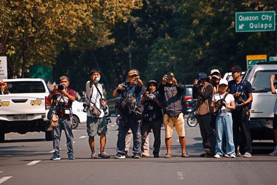 Photographers taking pictures on a busy street in Quezon City, Philippines. (Photo by Mico Medel on Pexels)