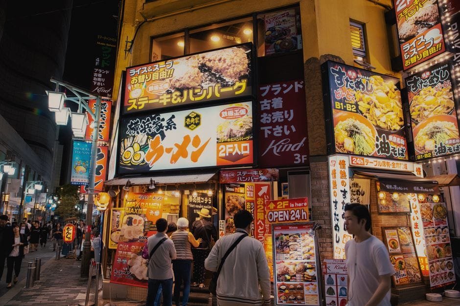 Lively Tokyo street featuring illuminated restaurant signs and bustling night activity. (Photo by Tony  Wu on Pexels)