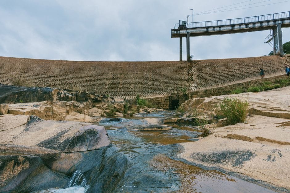 A beautiful landscape shot of a rocky river with a dam in the background, perfect for environmental themes. (Photo by FOX ^.ᆽ.^= ∫ on Pexels)