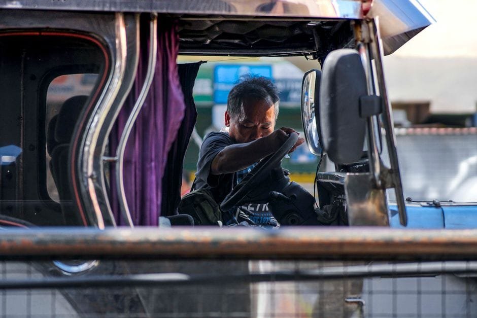 A jeepney driver napping inside his vehicle in Manila, Philippines. Daytime scene capturing urban life. (Photo by Julius M on Pexels)