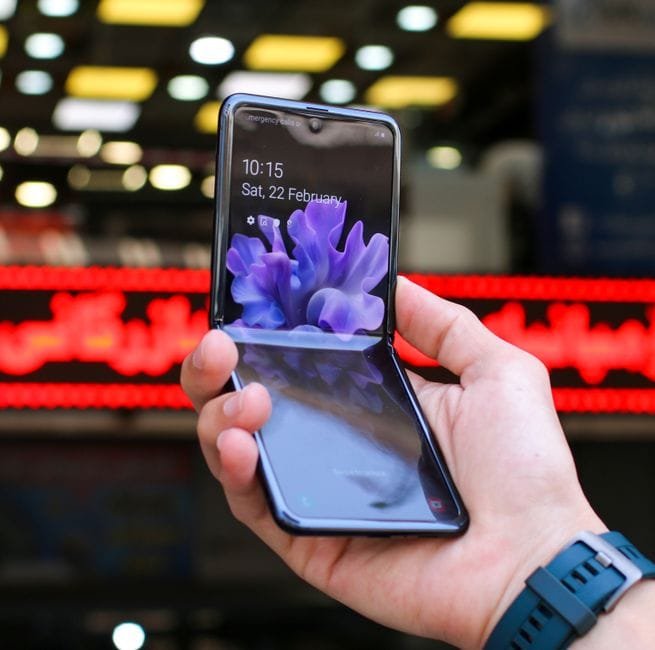 Close-up of a modern flip smartphone held in hand, showcasing innovative technology outdoors in a bustling city. (Photo by Zana Latif on Pexels)