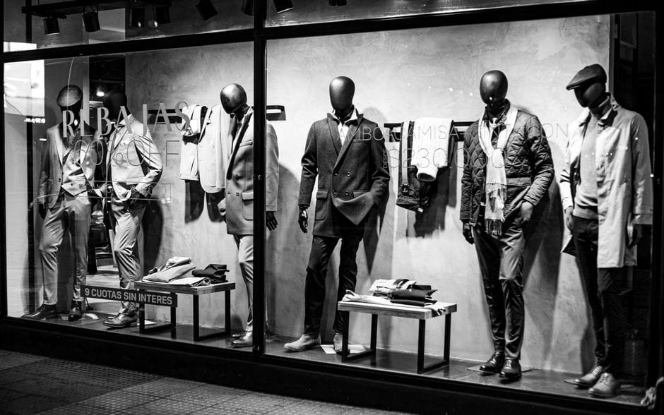 Black and white photo of elegant male mannequins in a clothing store window, Bahía Blanca. (Photo by Alex Dos Santos on Pexels)