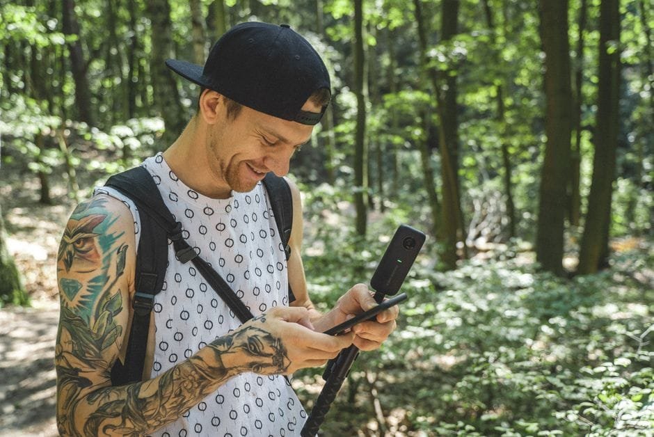 A person using a camera in a sunlit forest in Berlin, Germany, enjoying nature and exploration. (Photo by Maik Kleinert on Pexels)